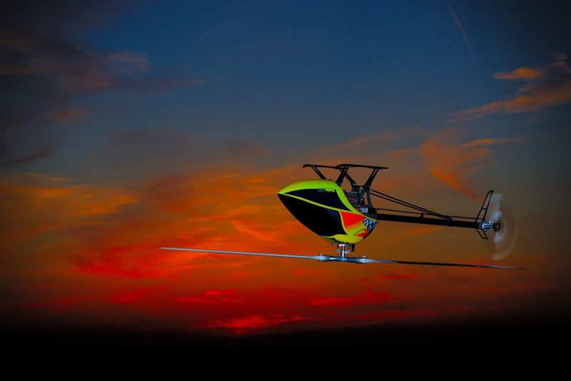 Helikopter im Rückenflug vor Sonnenuntergang
